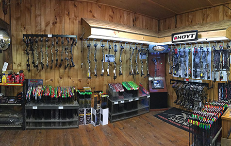Inside the Straight Arrow Archery pro shop — racks of compound bows and rows of arrows